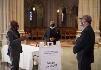 three men standing talking at cathedral