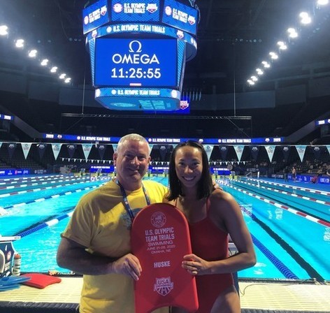 man standing next to woman, in front of a pool