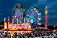 Scenic view of fair rides at night with the crowd