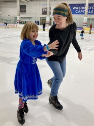 A mom and daughter ice skating