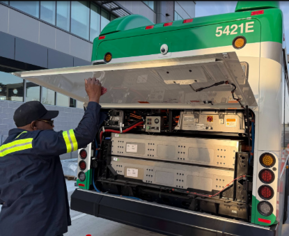 ART Electric Bus and a Mechanic looking at the back of the bus 