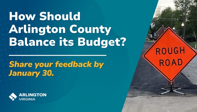 An orange diamond sign on a paved road warns of a "Rough Road" ahead.