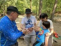 A family touching a lizard being held by naturalist, Rob.