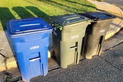 Trash, recycling and organics carts lined up at the curb.