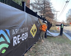Construction workers pinning up Arlington Re-Gen banner.