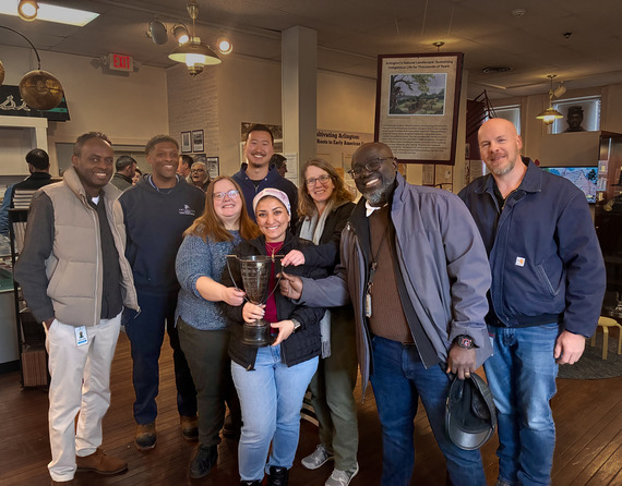Group photo of Water Pollution Control Plant employees, with one holding a trophy.