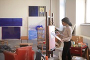 Artist painting in a studio.