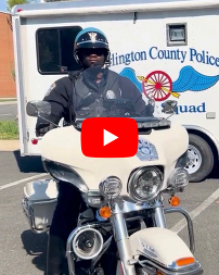 Arlington County Police officer on his motorcycle. YouTube play button in middle of image