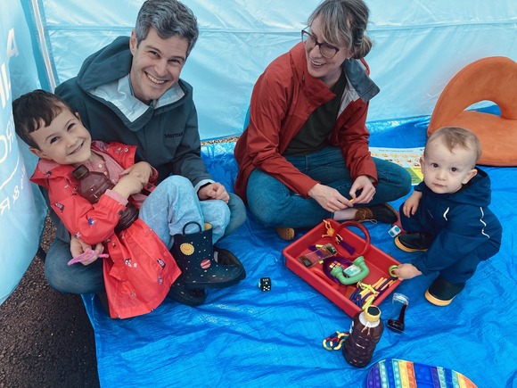 A family sitting inside the sensory tent playing with toys