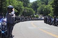 Dozens of officers lining the street on both sides as they salute