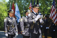 An officer carrying Corporal Barry Foust's urn