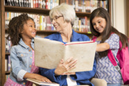A woman reading to two children.