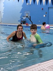 A woman and son swimming in a pool.