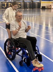 A man in a wheelchair wearing skates.