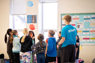 An Arlington Staff member supervising a group of young children during camp