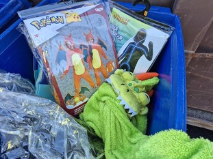 Donated Halloween costumes in a blue bin.