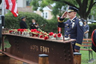 An ACPD officer salutes after placing a rose on the 9/11 Memorial at Station 5.