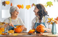 Two women decorating pumpkins.