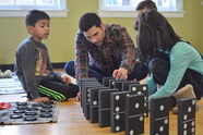 family of three playing a game of dominoes