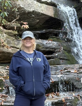 Karen Gray standing in front of Hanging Rock waterfall