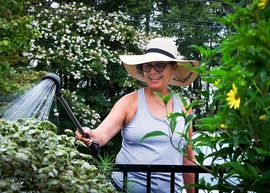 A woman tending to flowers in a garden