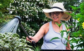 A woman tending to flowers in a garden