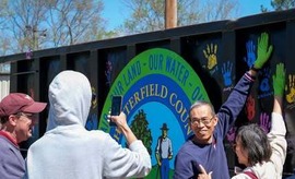 A Chesterfield resident puts his painted handprint on a recycling container at the 2024 Earth Day Festival