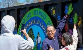 A Chesterfield resident puts his painted handprint on a recycling container at the 2024 Earth Day Festival