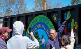 A Chesterfield resident puts his painted handprint on a recycling container at the 2024 Earth Day Festival