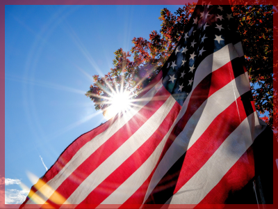 USA Flag flying in front of the sun.
