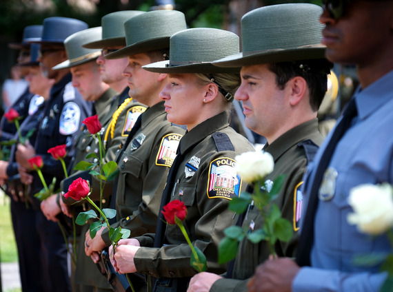 Chesterfield police officers and sheriff's deputies hold roses at the county's 2025 Law Enforcement Memorial cereremony