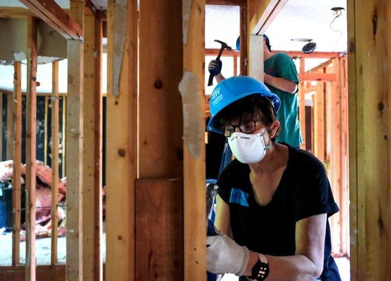 A volunteer with Habitat for Humanity helps renovate a blighted home on Sheldeb Drive