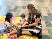 Picture of woman reading to two children