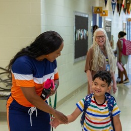 A Bellwood Elementary teacher greets a student on the first day of the new school year July 18
