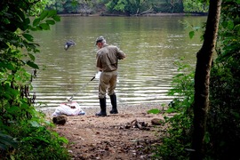 A man cleans up trash on the banks of the James River during the annual James River Regional Cleanup