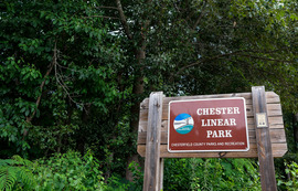 A wooden sign posted at the entrance to Chester Linear Park 