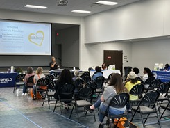 Picture of Claudia Perez from Greater Richmond SCAN giving a presentation at Kinship Fair