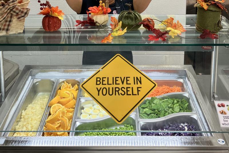A tray of food with a sign reading "Believe in Yourself"