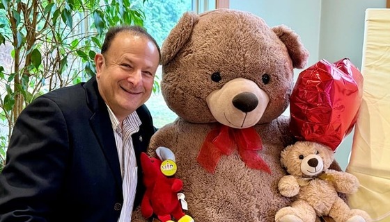 Dr. Miller next to two teddy bears
