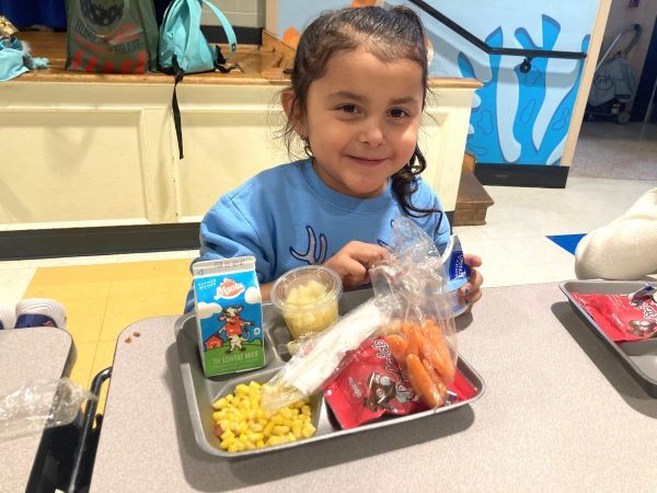 A young girl holding a school meal tray
