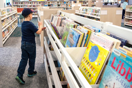 A boy looks through books available for rent at LaPrade Library