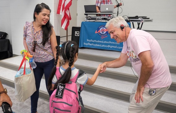 Dr. Joe Casey shakes the hand of a young girl at Chesterfield's Cafe con la Comunidad event