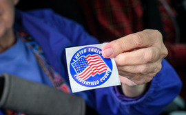 Woman holds sticker reading "I voted Early in Chesterfield County"