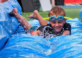 Child going down waterslide at Splash and Slide event