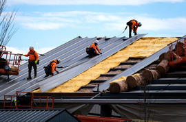 Construction workers install a metal roof on an industrial building in Chesterfield