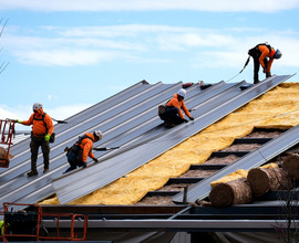 Construction workers install a metal roof on an industrial building in Chesterfield