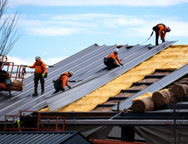 Construction workers install a metal roof on an industrial building in Chesterfield