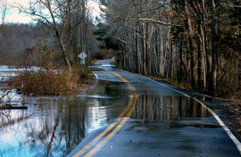 Swift Creek overtops its banks, partially flooding a section of Otterdale Road after a significant rainstorm