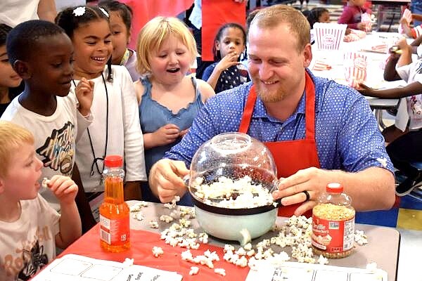 Hening Elementary students look on excitedly as their teacher pops popcorn for a science experiment