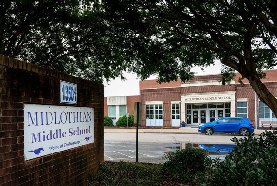 An exterior image of the front of Midlothian Middle School and the school's sign in the foreground
